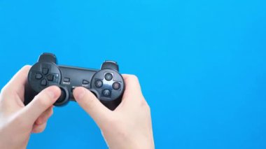 Close-up of a mans hand playing a game on a console on a blue chromakey background. 4k video