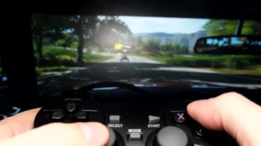 A young man plays car racing with a trackless joystick. Gamer and computer video games. Close-up of a streamer holding a joystick
