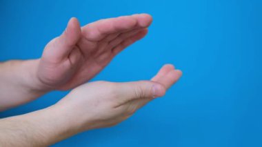 Close-up of male hands clapping against a blue screen background. Chromakey. 4k video