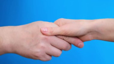 Handshake on a light blue background. Close up. High quality 4k video