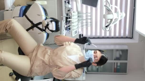 Жінка Стоматолог Сучасному Офісі Одягає Маску Окуляри Перед Лікуванням Вертикальне — стокове відео