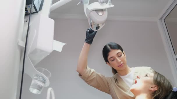 一位女牙医用黑色手套检查病人的口腔 牙医在牙科诊所的办公室进行体格检查 牙科和医疗保健的概念 — 图库视频影像