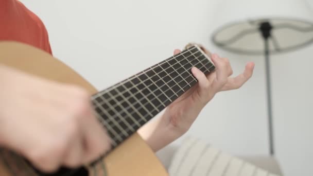 Joven Tocando Guitarra Habitación Está Sentado Sofá Disfrutando Apasionadamente Música — Vídeo de stock