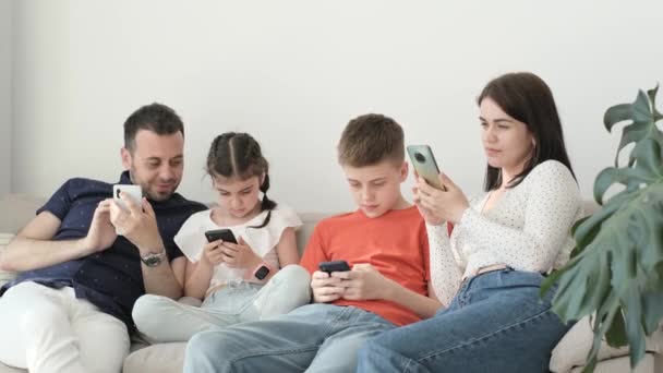 自宅でソファの上に休む大きな家族 彼らは現代の道具を使う インターネットへの依存の問題 — ストック動画