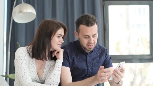Husband Wife Sitting Sofa Home Talking Looking Smartphone Video — Vídeos de Stock