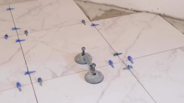 Repair in an apartment, a house. Large white tiles during laying. Professional tiling