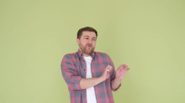 A Caucasian man is dancing beautifully in the studio on a dark yellow background. Dancing concept