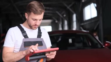 The car mechanic connects the tablet to the cars on-board diagnostics port and uses specialized software to diagnose problems with the cars engine