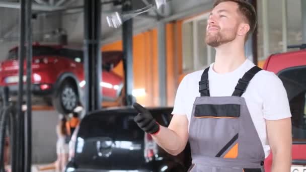 Uśmiechnięty Mechanik Kluczem Ręku Stoi Przed Samochodami Warsztacie Samochodowym Uśmiecha — Wideo stockowe