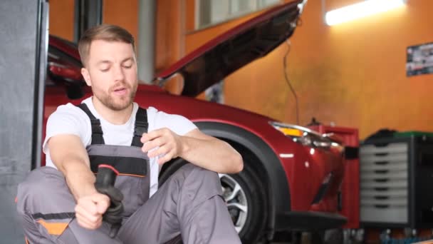 Een Vermoeide Reparateur Zit Naast Een Kapotte Auto Houdt Zijn — Stockvideo