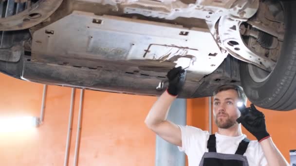 Ένας Μηχανικός Αυτοκινήτων Επισκευάζει Σασί Ενός Αυτοκινήτου Μια Υπηρεσία Αυτοκινήτων — Αρχείο Βίντεο