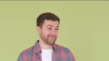 Surprised young man shaking his head on studio background. Slow motion.