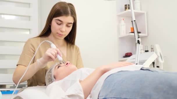 Ung Kvinna Ligger Kosmetologer Bord Föryngring Förfarande Rengöringsförfarande För Maskinvara — Stockvideo