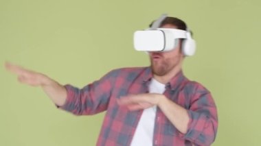 VR dance video, play VR music game. A man in a virtual reality headset is dancing on a yellow background. 4k video