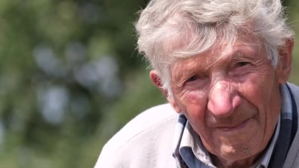 Ένας Πολύ Γέρος Κουρασμένος Γκρίζος Άντρας Κοιτάζει Την Κάμερα Πανούργα — Αρχείο Βίντεο