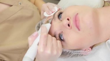 Close-up of beautiful womans face during ultrasonic peel skin procedure at spa salon.Ultrasound facial peeling. 