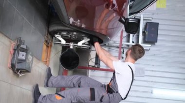 Vertical video of a mechanic checking the chassis for any damage or wear. Balancing the chassis of the car