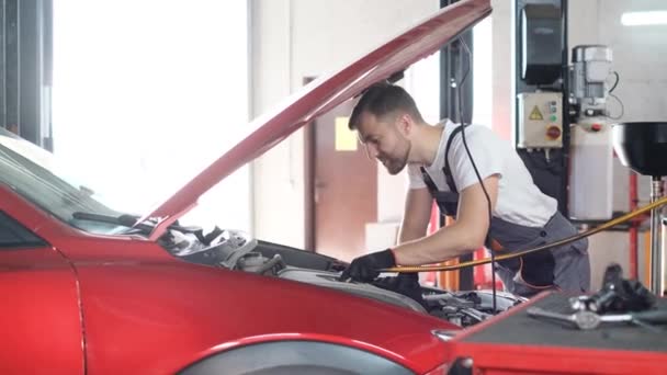 Een Professionele Automonteur Onderzoekt Een Auto Bij Een Autodienst Voert — Stockvideo