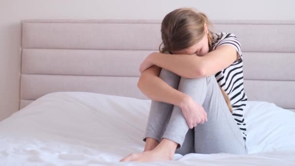 隠れた頭でベッドに座っている若い女性を動揺させます 女性のうつ病 ストレス — ストック動画