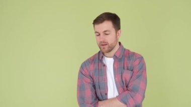 A man who thinks and surveys the environment. He stands on the background in the studio. The guy is concentrated and engrossed in his thoughts, giving a feeling of deep thoughtfulness.