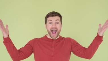Stüdyoda arka planda duran yakışıklı adam hevesli görünüyor ve ellerini yana açıyor. Yavaş çekim