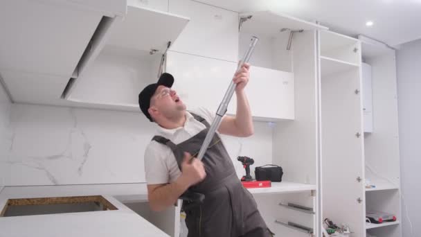 一个非常有趣的工匠在修理过程中 模拟弹吉他 使用工具 家具装配工玩得很开心 — 图库视频影像