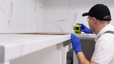 Professional craftsman, electrician during repair work using an electronic level. High-quality repairs to the house