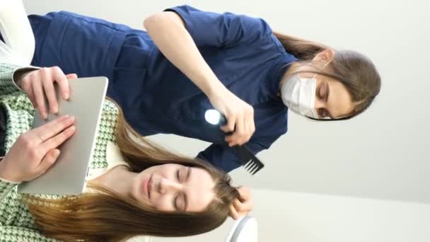 电脑三联影印机 一位三叶虫学家在诊所里用毛管检查病人的头发 在头皮上方运行滴管 并在监视器屏幕上查看结果 — 图库视频影像