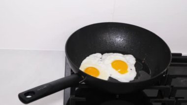 Cooking scrambled eggs for breakfast. Eggs are fried in a pan, the food is rich in proteins.