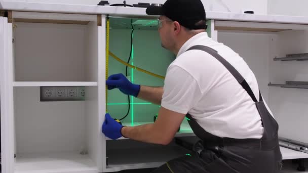 Master Uniform Checks Quality Installed Kitchen Cabinets Laser Level While — Stockvideo