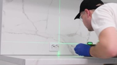 A professional electrician checks the quality of the installed outlet using a digital level. High-quality and professional repairs in the house
