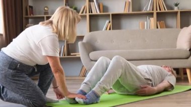 Emekli yaşlı çift evde spor yapıyor, büyükannem dedeme egzersiz yaptırıyor, birlikte spor yapıyorlar.