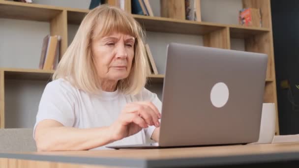 一位视力不好的祖母坐在笔记本电脑前 头疼极了 一个在电脑前消磨时光的退休女人疲惫的双眼 — 图库视频影像