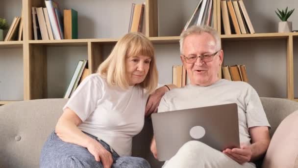 Nagyszülőknek Van Egy Videohívásuk Laptoppal Kanapén Ülnek Internetet Használják Európai — Stock videók