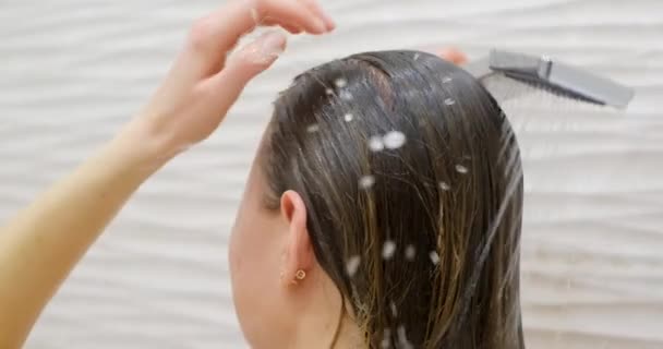 バスルームでシャワーを浴びている女性のクローズアップ 美しい長い髪のケア — ストック動画