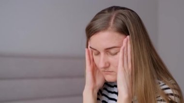 Bir kadın elleriyle şakaklarını ovuştururken baş ağrısı hisseder. Derin nefes alma ve meditasyon gibi rahatlama teknikleri. İş yerinde yorgunluk
