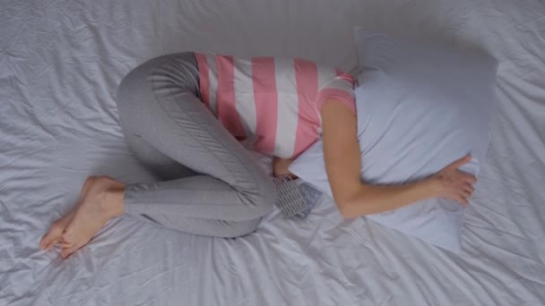 一位年轻妇女躺在床上 在月经期间患有腹痛 服用止痛药 4K视频 — 图库视频影像