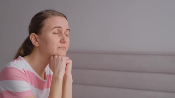 孤独な若いヨーロッパの女性は ベッドの上に座って 彼女は自宅で 悲しいことに離れて見て落ち込んでいる 4Kビデオ — ストック動画