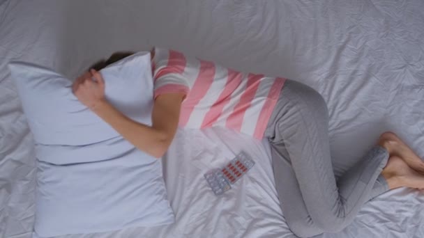 中年の女性は 彼女の月経周期のために眠ることができない ベッドに横になり 胃の痛みと嘘をつきます 女の子病気または悲しいうつ病睡眠に家 — ストック動画
