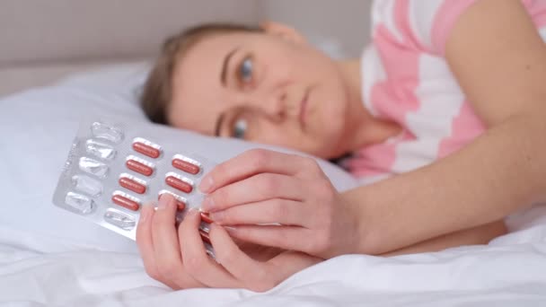 腹痛を訴える女性が鎮痛剤を飲み ベッドに横になっている 痛みを伴う時代 女性の精神的なサイクル — ストック動画