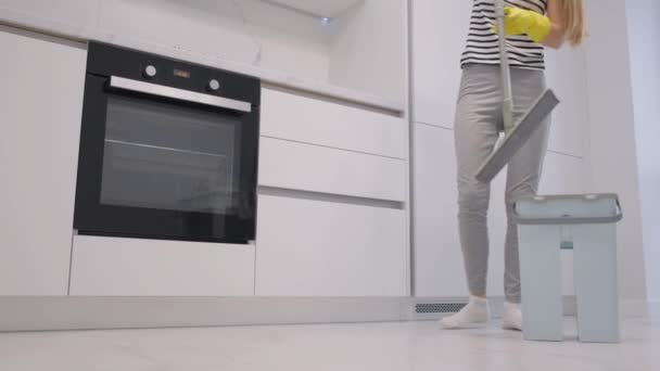 一个快乐的年轻女人打扫房子 用拖把擦拭地板 家庭主妇喜欢做家务活 4K视频 — 图库视频影像
