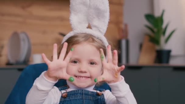一个长着小兔子耳朵的孩子手里拿着彩蛋玩耍 复活节假期的概念 — 图库视频影像