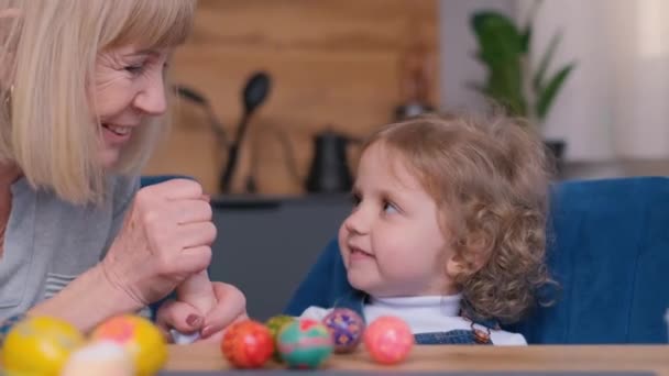 Γιαγιά Και Εγγονή Αγκαλιάζονται Ενώ Βάφουν Αυγά Στην Κουζίνα Ευτυχισμένη — Αρχείο Βίντεο