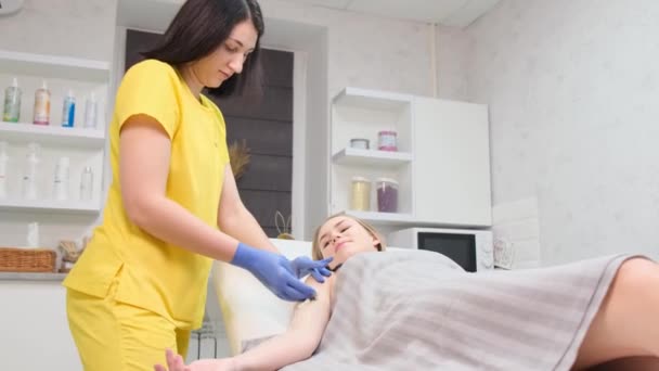 Cosmetician Într Costum Galben Epilează Mâinile Unui Client Tânăr Pasta — Videoclip de stoc