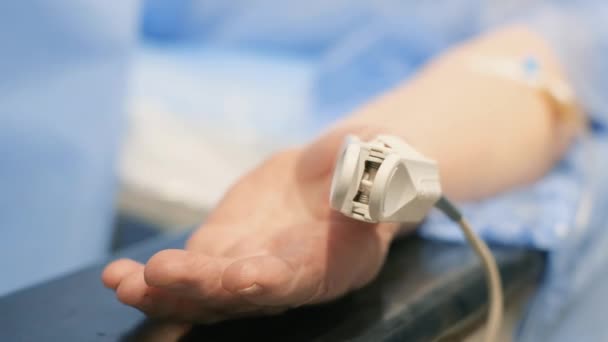 手術中の指の心拍数モニターのクローズアップ 医師は患者の健康を監視する — ストック動画