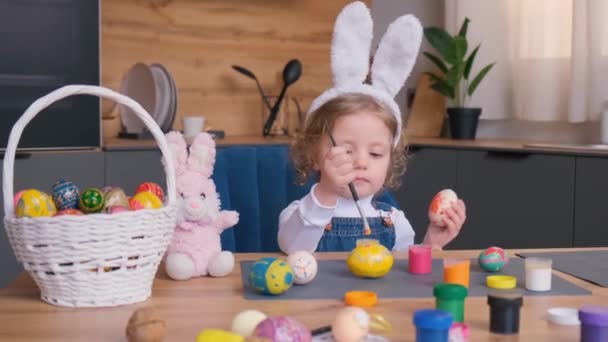复活节那天 一个长着小兔子耳朵的可爱小女孩 小金发女郎在家里为以斯帖节而在煎蛋 — 图库视频影像