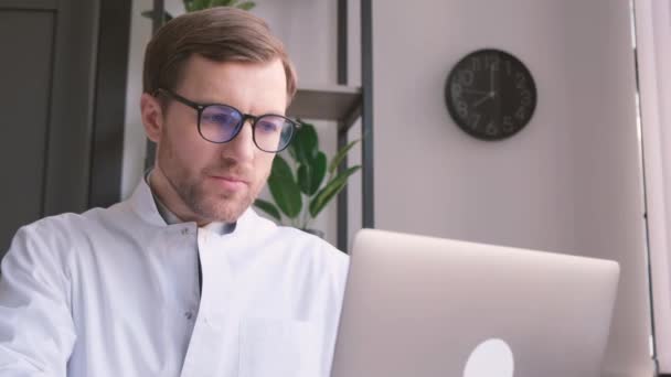 Focado Grave Jovem Médico Masculino Óculos Uniforme Branco Trabalhando Line — Vídeo de Stock