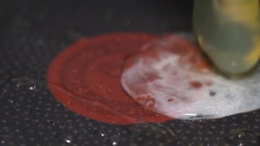 Tavaya dökülen yumurtaların büyütülmüş görüntüsü. Yumurta sarısı ve beyaz.