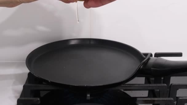 一只手打破了一个鸡蛋 把它倒在一个热锅上 炉子上的一个热锅 用来做饭 — 图库视频影像