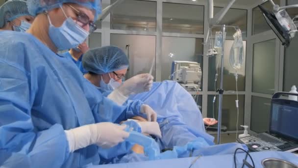 一位静脉注射学家 外科医生和助手用一种现代的 创新的激光消融方法对有静脉曲张静脉的腿进行手术 4K视频 — 图库视频影像